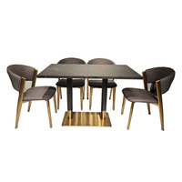 Table à manger en pierre frittée noire avec base en acier inoxydable et accents dorés