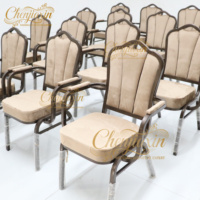 Chaises de banquet empilables de luxe en velours et métal avec accoudoirs, personnalisées pour hôtels et restaurants, collection 2026, idéales pour événements