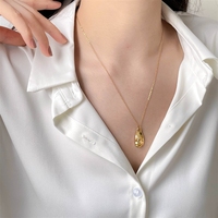 Collier élégant pour femme à plusieurs niveaux avec un design vintage, orné d'un pendentif abstrait en forme de masque facial tridimensionnel
