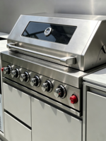 Cuisine extérieure avec machine à glaçons intégrée, barbecue à gaz, réfrigérateur à double tiroir, évier, porte-couteaux et unité en pierre