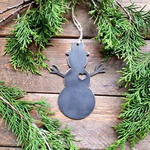 Adorno navideño rústico de metal en bruto con forma de muñeco de nieve y corazón recortado. Silueta clásica de muñeco de nieve con sombrero de copa estilo ramas. - Product Image 1