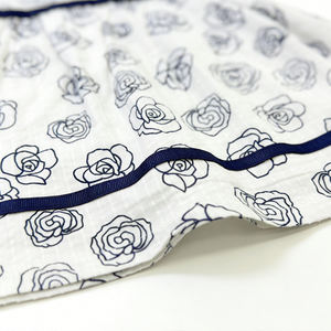 فستان مطبوع بالورود الزرقاء على خلفية بيضاء بالجملة، بدون أكمام، تنورة واسعة، حواف كحلية، ظهر مفتوح، تصميم بفيونكة - Product Image 4