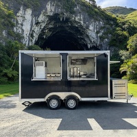 Remorque alimentaire noire avec deux fenêtres de service et une cuisine complète, comprenant une hotte, une plancha et une friteuse, idéale pour les entreprises de restauration rapide à fort volume.