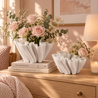 Vase en céramique blanche avec un design sculptural fluide pour fleurs et décoration intérieure