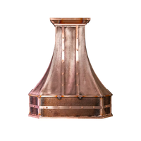 Hotte de cuisine de luxe artisanale sculptée en cuivre, forme cloche, avec tablier arqué et couronne, sur mesure, finition patine brossée, avec système d'aération