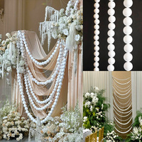 Mur de toile de fond élégant en satin blanc, rideau de fond luxueux à plis croisés avec chaîne de perles pour mariage en extérieur dans un jardin