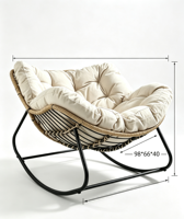 Fauteuil à bascule moderne en rotin tressé, capitonné avec boutons, coussin épais beige, structure en métal noir, coque incurvée surdimensionnée pour salon