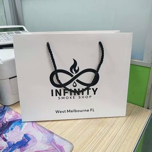 ออกแบบโลโก้ตามสั่ง ถุงของขวัญสุดหรูสำหรับเสื้อผ้า บรรจุภัณฑ์กระดาษแข็งสีขาว หูหิ้วริบบิ้น สีตามสั่ง - Product Image 1