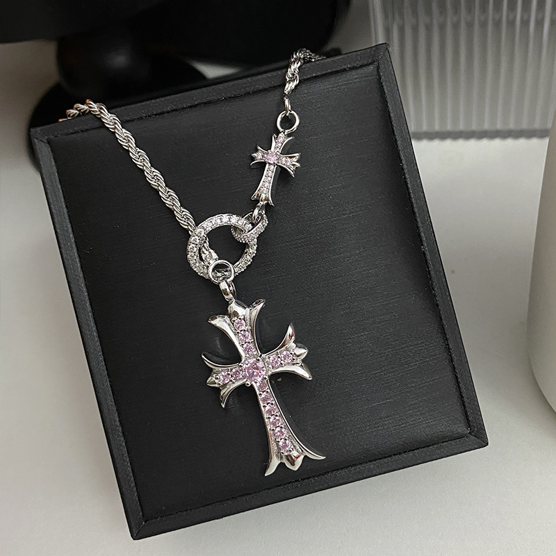 Une croix avec une chaîne torsadée en diamant rose