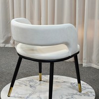 Chaise de salle à manger moderne en velours blanc cassé, dossier souple en U, pieds avec embouts dorés, structure en métal noir, idéale pour la maison, le bureau ou les espaces publics.
