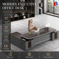 Bureau de direction moderne en forme de L avec plateau aspect bois foncé, base gris foncé et ports d'alimentation