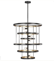 Lustre à anneaux superposés noir Cano Lighting, anneaux métalliques avec intérieur doré sur un pied vertical, luminaire de plafond moderne et industriel