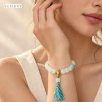 Bracelet en perles de pierres précieuses blanches avec accents turquoise et pompon décoratif