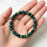 Bracelet de luxe en perles rondes de huit millimètres couleur émeraude, avec centre en forme de baril et entretoises dorées, en jade vert