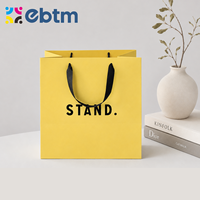 Sacs cadeaux en papier jaune mat personnalisés en gros avec poignées en ruban noir pour sacs cadeaux cosmétiques