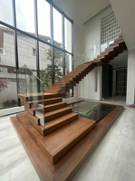 Escalier contemporain en pierre empilée, marches en pierre frittée et bois massif, design artistique pour usage résidentiel