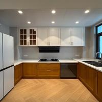 Meuble de cuisine sans poignée sur mesure, placage bois clair, tiroirs à fermeture amortie pour appartement urbain, espace de cuisson compact