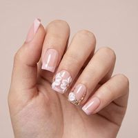 Faux ongles à presser carrés moyens, blancs nude, diagonaux, style French, en acrylique, couvrance totale, avec ligne de paillettes or rose, courts