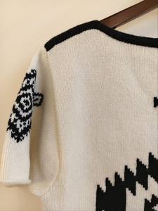 "Pull tricoté à manches courtes artisanal avec motif géométrique aztèque audacieux, design élégant de contraste noir et blanc." - Product Image 4