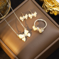 Nouvel ensemble de bijoux haut de gamme et tendance pour femme : boucles d'oreilles clous et bague en acier titane plaqué or avec pendentif nœud papillon, modèle populaire sur internet