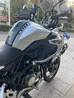 Moto de tourisme d'aventure à deux cylindres refroidie par eau de 502 cm3, blanche et noire, avec bagages et barres de protection entièrement en aluminium