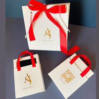 Boîte cadeau de luxe blanche pour bijoux, personnalisée avec estampage à chaud doré et ruban satiné, idéale pour les bijouteries.