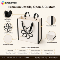 Sac en papier blanc personnalisé avec poignée en ruban noir, pelliculage mat, motif floral imprimé pour les boutiques de cadeaux et les magasins de détail