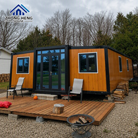Casa Contenedor Expandible de Madera Cálida con Acabado de Grano de Madera, Almacén, Terraza, Cabaña Prefabricada, Entrada de Cristal, Casa de Vacaciones en Bosque/Montaña, Base de Muelle