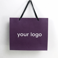 Sac en papier teinté violet foncé avec poignées en corde tressée noire, soufflet et impression de logo blanc personnalisé pour marques de cosmétiques