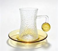 Ensemble de tasses à café en verre borosilicate martelé, forme sablier texturée, avec poignée boule ambrée, capacité 120 ml, et soucoupe à thé