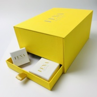 Boîte cadeau pour bijoux A1 gaufrée blanche avec zone de texte dorée, sac jaune et surface tactile pour la remise aux clients de marques de boutiques