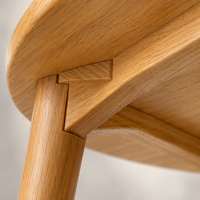 Table de cuisine ronde moderne avec pieds en bois massif, barre transversale renforcée et structure de support triangulaire, style minimaliste