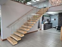 Escalier flottant cantilever d'intérieur avec balustrade en panneaux de verre, support dissimulé et options multiples de marches en bois