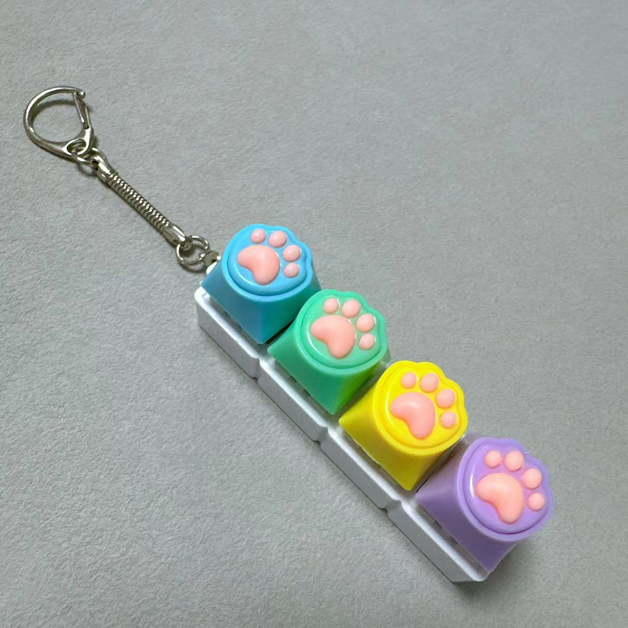 Coque blanche à quatre boutons - motif patte de chat en silicone en bleu, vert, jaune et violet.
