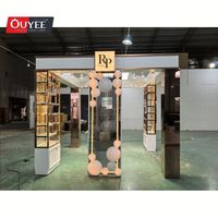 Kiosque de présentation de parfums et cosmétiques moderne, luxueux, pliable et rotatif en 3D avec éclairage LED et thème rose pour les centres commerciaux