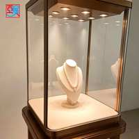Présentoir à bijoux en verre avec cadre doré élégant et personnalisable, éclairé par LED, pour magasin de bijoux