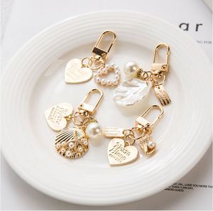 Fashion Elegant Heart Shaped <b>Shell</b> Imitation Pearl Keychain Metal Bag Pendant Gold Letter Jewelry Earphone Gift for Women - Product Image 1