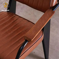 Chaise de salle à manger industrielle vintage en cuir avec accoudoirs en bois, structure en métal noir, chaise rembourrée pour restaurant, café, bistrot