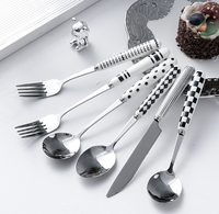 Ensemble de couverts en acier inoxydable à motif blanc et noir, avec poignées en céramique, pour une table de cuisine lumineuse et coordonnée