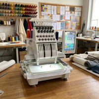 Machine à broder et à coudre avec système à double fonction pour la confection de vêtements