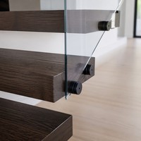 Escalier flottant moderne avec marches en chêne massif, garde-corps en verre, main courante noire, design personnalisé pour villa de luxe, penthouse, hall d'hôtel