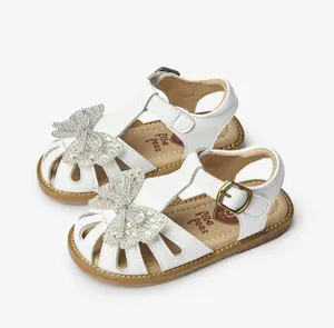 Sandalias de Punta cerrada con lazo brillante para niñas, zapatos de cuero blanco con correa en T