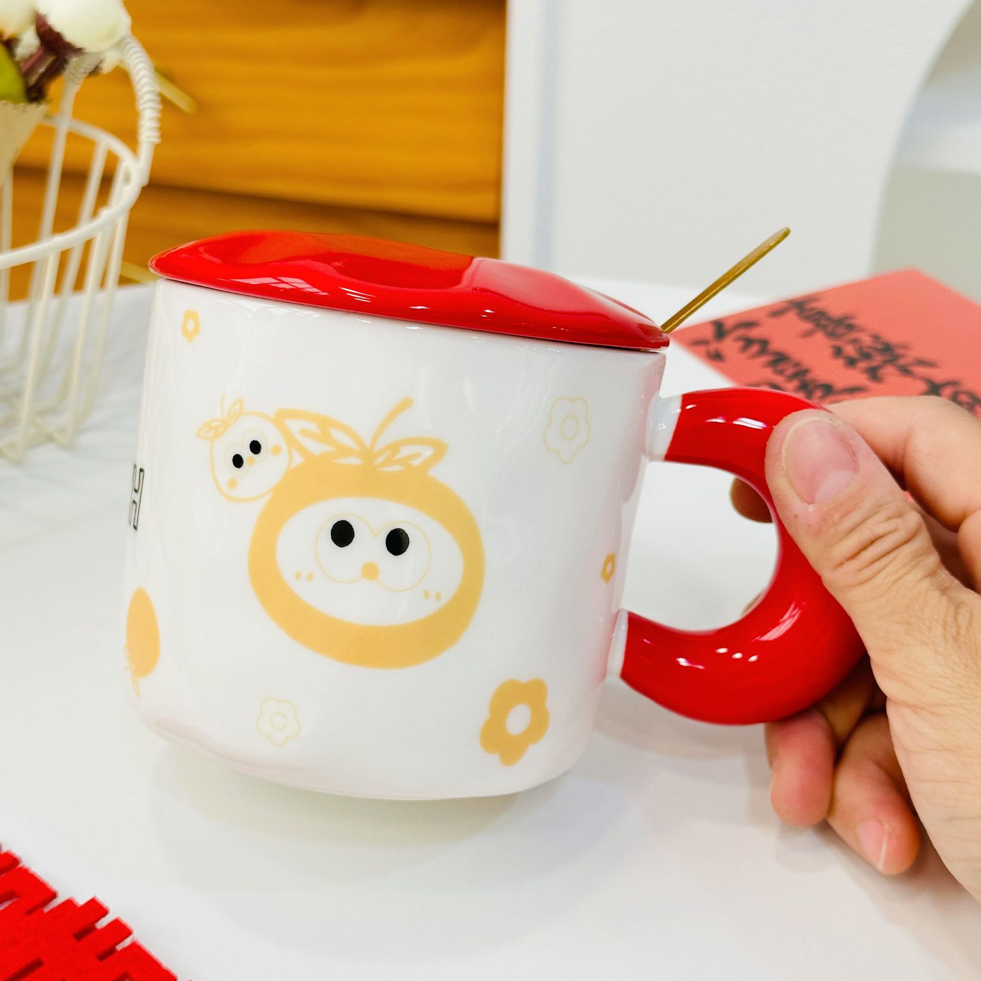Taza de cerámica roja anaranjada superior izquierda con la tapa y la cuchara