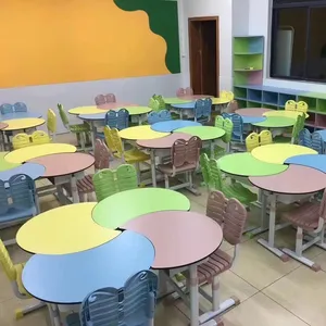 Produsen menyediakan meja dan kursi siswa merah muda yang kokoh untuk kelas sekolah SMA