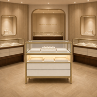 Socle de présentation de bijoux cylindrique à LED |   Enclos en verre avec structure en métal doré |   Boutique de bijoux haut de gamme de luxe