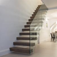 Escalier flottant minimaliste avec marches en bois et balustrade en panneaux de verre transparent