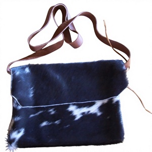 This is a black and white hair-on cowhide <b>leather</b> cross body bag with a tan <b>leather</b> strap - Product Image 1