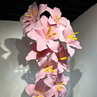 Installation artistique moderne de fleurs géantes en mousse de luxe, idéale pour la décoration de vitrines de centres commerciaux et de mariages