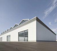 Bâtiment industriel préfabriqué en structure acier avec toit en dents de scie et éclairage naturel en verre