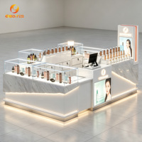 Kiosque cosmétique de centre commercial, comptoir d'exposition de beauté à texture marbrée avec éclairage LED et vitrine en verre
